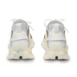 Puede incluir: Un par de zapatillas blancas con parte superior de punto, cordones blancos y una suela gruesa, transl&uacute;cida y de color blanco roto, con sutiles motas multicolores incrustadas en la zona del tal&oacute;n y el mediopi&eacute;.