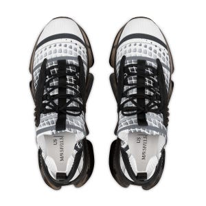 May include: A pair of athletic trainers featuring a white and grey grid pattern on the upper, black laces, and a translucent dark grey sole. The interior insole is clearly printed with the text US M/9.5 F/11.5, indicating the shoe size.