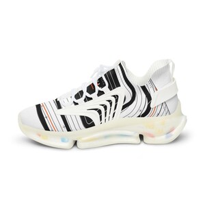 K&ouml;nnte beinhalten: Ein wei&szlig;er Sneaker mit einem schwarzen, topografischen Linienmuster, d&uuml;nnen orangefarbenen Akzenten und wei&szlig;en Schn&uuml;rsenkeln. Der Schuh hat eine durchscheinende, klobige Sohle mit kleinen, bunten Sprenkeln und einem wei&szlig;en Fersenriemen.