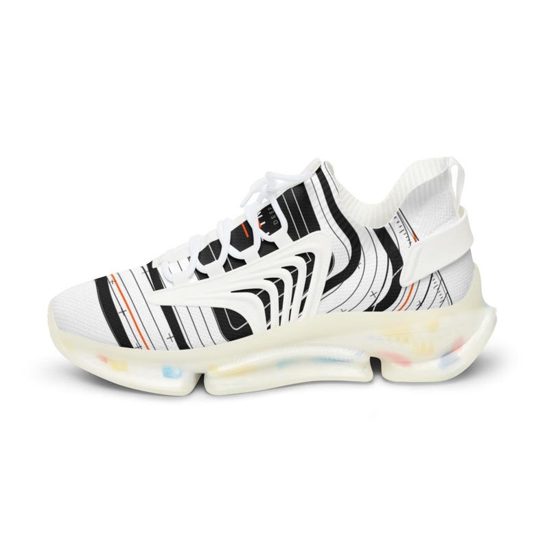 K&ouml;nnte beinhalten: Ein wei&szlig;er Sneaker mit einem schwarzen, topografischen Linienmuster, d&uuml;nnen orangefarbenen Akzenten und wei&szlig;en Schn&uuml;rsenkeln. Der Schuh hat eine durchscheinende, klobige Sohle mit kleinen, bunten Sprenkeln und einem wei&szlig;en Fersenriemen.