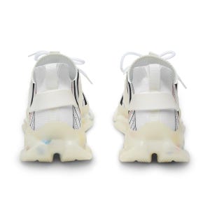 K&ouml;nnte beinhalten: Ein Paar wei&szlig;e Sportschuhe mit einem Strickobermaterial, schwarzen Linienmustern und d&uuml;nnen roten Akzenten. Die Schuhe haben wei&szlig;e Schn&uuml;rsenkel, eine strukturierte Fersenlasche und eine klobige, durchscheinende, cremewei&szlig;e Sohle.