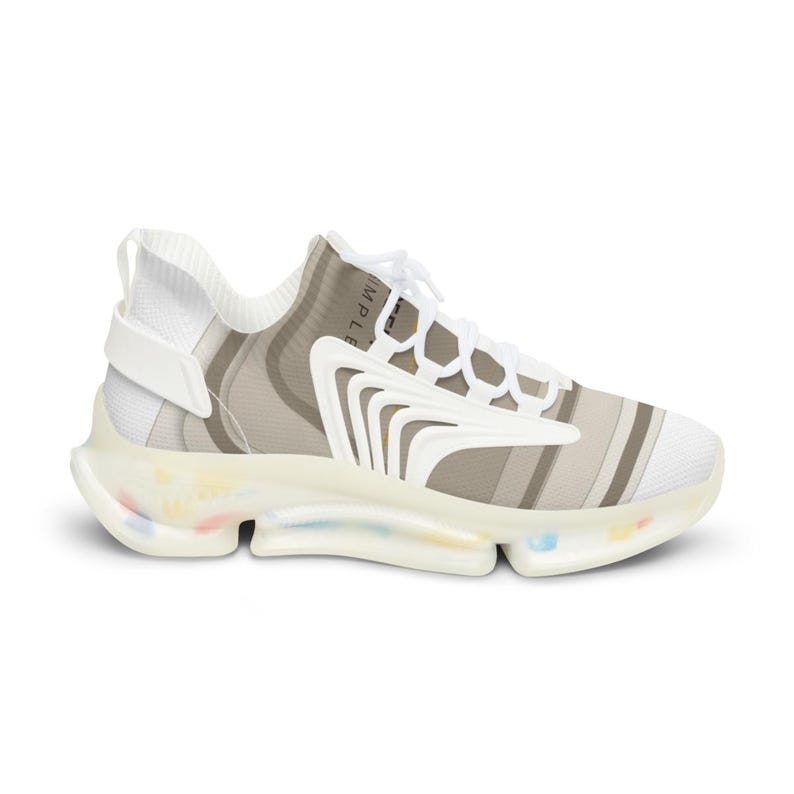 Puede incluir: Una zapatilla deportiva blanca y beige con un empeine estampado, superposiciones blancas curvas, cordones blancos y una suela transl&uacute;cida con peque&ntilde;as motas multicolores. La palabra SIMPLE es parcialmente visible en el lateral.