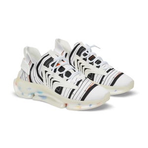 K&ouml;nnte beinhalten: Ein Paar wei&szlig;e Sneaker mit schwarzem Nadelstreifenmuster und kleinen orangefarbenen Akzenten. Die Schuhe haben wei&szlig;e Schn&uuml;rsenkel, ein strukturiertes Overlay-Design und eine durchscheinende, klobige Sohle mit dezenten, bunten Sprenkeln.