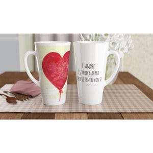 Peut inclure: Deux tasses à latte en céramique blanche. L'une présente un grand motif de ballon en forme de cœur rouge à l'aquarelle. L'autre affiche le texte imprimé en noir : L'AMORE È L'UNICA ARMA CHE DEVI TENERE CON TE. Forme cylindrique haute et effilée.