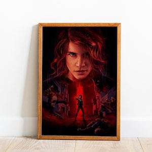 May include: A framed poster featuring a digital illustration of a person with wavy reddish-brown hair in the foreground, set against a dark, red-toned background with a smaller figure standing in a ruined environment surrounded by debris.
