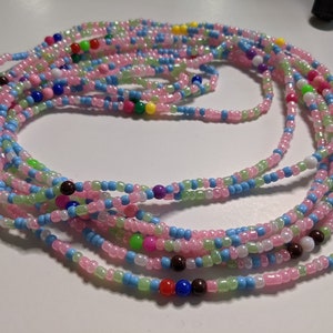 May include: A multi-strand beaded waist chain with pink, light blue, green, and white beads. The chain has colorful accent beads in red, blue, purple, and yellow.