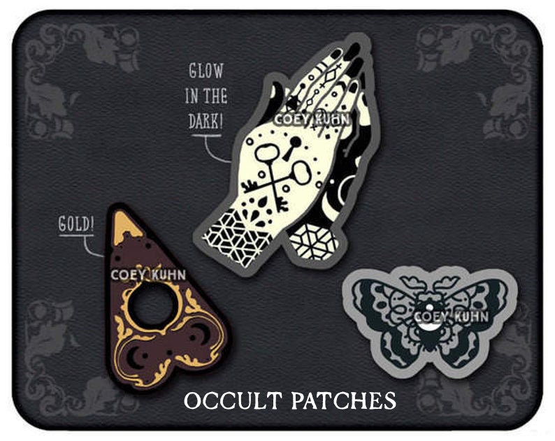 Puede incluir: Tres parches termoadhesivos en blanco y negro con temas ocultos. Los parches representan un par de manos en oraci&oacute;n, una planchette de Ouija y una polilla. El texto "COEY KUHN" aparece en cada parche. El texto "GLOW IN THE DARK!" aparece sobre el parche de las manos en oraci&oacute;n. El texto "GOLD!" aparece sobre el parche de la planchette. El texto "OCCULT PATCHES" aparece debajo de los parches.