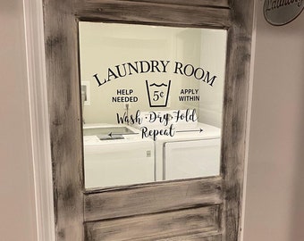 May include: A white wooden door with a glass panel featuring a black and white laundry room sign that reads "Laundry Room, Help Needed, 5¢, Apply Within, Wash - Dry - Fold - Repeat". The sign is framed by a black border. The door has a black metal handle and a black metal track.