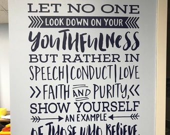 May include: A white wall with a black and white inspirational quote that reads "Let no one look down on your youthfulness, but rather in speech, conduct, love, faith and purity, show yourself an example of those who believe. 1 Timothy 4:12".