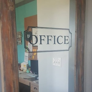 May include: A rustic wooden door with a glass panel featuring a black and white "OFFICE" sign. The door has a black metal handle and a black chalkboard panel.