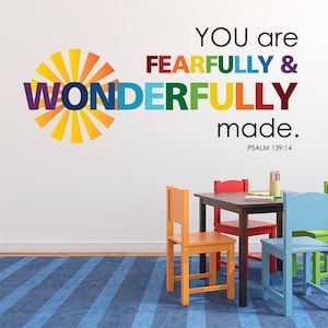 May include: A colourful wall decal with the text "You are fearfully & wonderfully made. Psalm 139:14" with a sunburst design. The decal is displayed in a room with a table and four chairs.