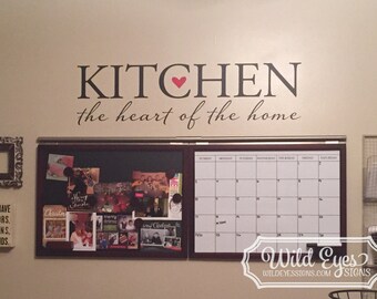 May include: A black and white vinyl wall decal with the text "KITCHEN the heart of the home" with a red heart in the middle of the word "KITCHEN".