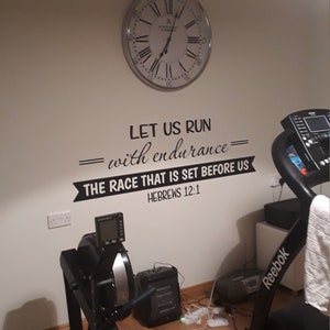 May include: A home gym with a rowing machine, a treadmill, and a clock on the wall. The wall has a motivational quote that reads "Let us run with endurance - the race that is set before us - Hebrews 12:1".
