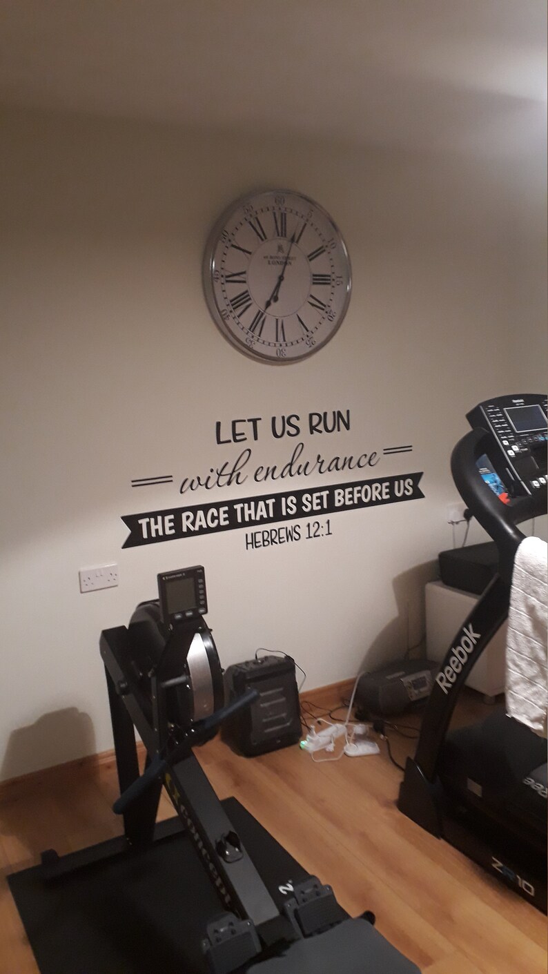 May include: A home gym with a rowing machine, a treadmill, and a clock on the wall. The wall has a motivational quote that reads "Let us run with endurance - the race that is set before us - Hebrews 12:1".
