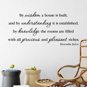 May include: A white wall with a black calligraphy quote from Proverbs 24:3-4, "By wisdom a house is built, and by understanding it is established; by knowledge the rooms are filled with all precious and pleasant riches."