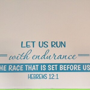 May include: A blue and white motivational quote on a white wall. The quote reads "Let us run with endurance - the race that is set before us - Hebrews 12:1".