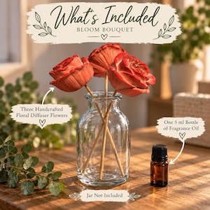 May include: A clear glass vase containing three handcrafted floral diffuser flowers with reddish-orange petals on thin stems. Next to the vase is a small amber glass bottle labeled as a 5 ml bottle of fragrance oil. Text reads What's Included.