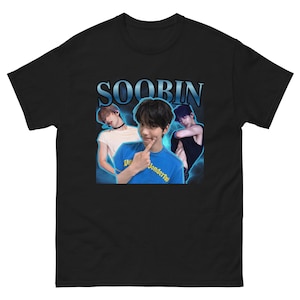 May include: A black short-sleeve t-shirt featuring a graphic print of the name SOOBIN in blue letters above three photographic images of a person. The central image shows a person in a blue shirt, flanked by two other images of the same person.