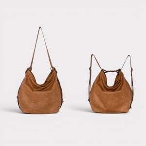 May include: A tan hobo bag with a slouchy silhouette and adjustable straps. The bag is shown in two configurations: one with a single long shoulder strap and another with two straps positioned to function as a backpack, both featuring metal hardware.
