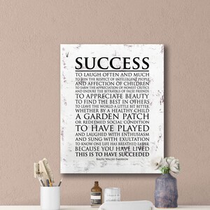 May include: A white canvas print with a black and white text quote about success by Ralph Waldo Emerson. The quote reads: "To laugh often and much... This is to have succeeded."