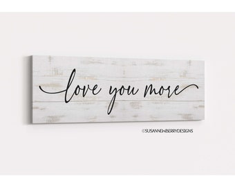Può includere: Segno in legno sbiancato con scritta nera che dice "love you more".