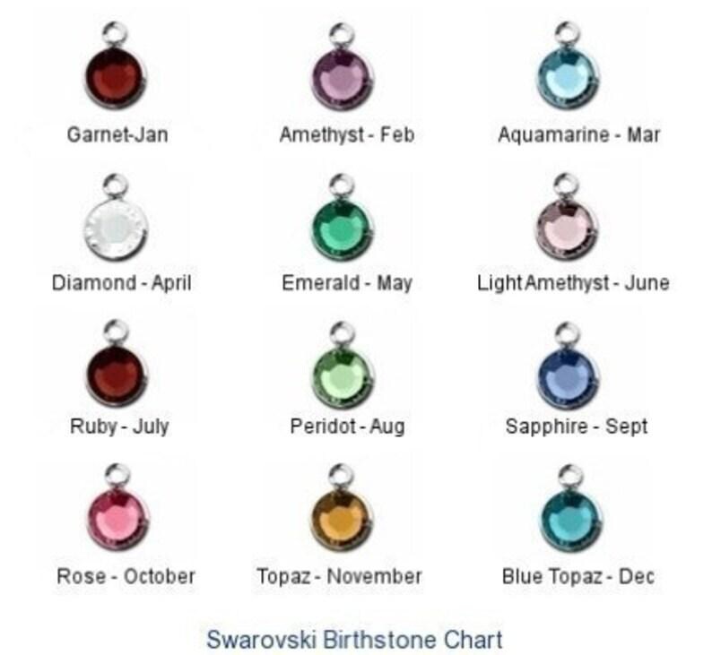 May include: A chart showing the birthstones for each month of the year. The chart features a small silver charm with a colored crystal for each month. The crystals are: Garnet, Amethyst, Aquamarine, Diamond, Emerald, Light Amethyst, Ruby, Peridot, Sapphire, Rose, Topaz, and Blue Topaz.