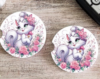 May include: Two white ceramic coasters with a cartoon image of a white cat with pink flowers and a pink bow. The cat is wearing a flower crown.