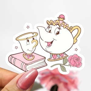 May include: A sticker featuring a cartoon teapot and teacup from the Disney movie Beauty and the Beast. The teapot is white with a pink and blue trim and has a pink rose on the side. The teacup is yellow with a pink and blue trim and has a pink rose on the side. The sticker also features a pink book and a pink rose.
