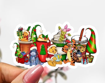 May include: A Christmas-themed sticker featuring Winnie the Pooh and his friends enjoying festive drinks. The sticker features a red, green and white colour scheme with characters like Tigger, Eeyore and Piglet.