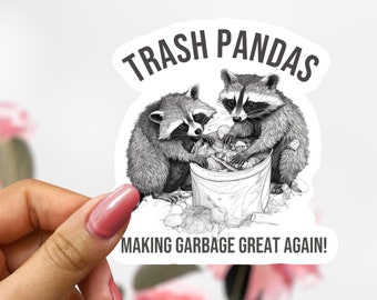 May include: A black and white sticker featuring two raccoons with the text "Trash Pandas Making Garbage Great Again!"