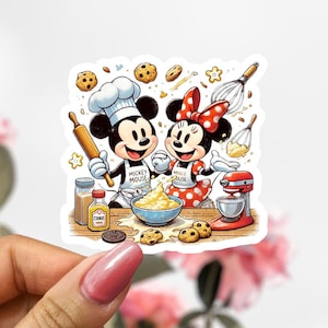 May include: A colorful sticker featuring Mickey and Minnie Mouse in chef attire, baking cookies. Mickey wears a chef's hat and apron with "Mickey Mouse" printed on it. Minnie wears a polka-dot bow and apron with "Minnie Mouse" printed on it. Baking tools and ingredients surround them.