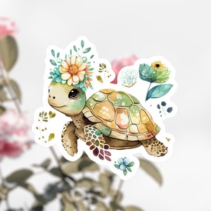 Puede incluir: Una ilustraci&oacute;n de acuarela de una linda tortuga con una corona de flores. La tortuga es verde y marr&oacute;n con un caparaz&oacute;n amarillo. Las flores de la corona son amarillas, blancas y azules.