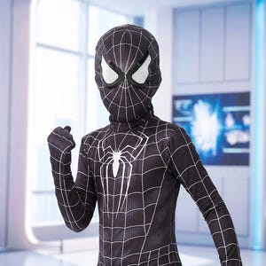 May include: A black full-body costume featuring a white spider emblem on the chest and a white web pattern across the fabric. The outfit includes a matching headpiece with white mesh eye coverings, designed to cover the head and torso completely.