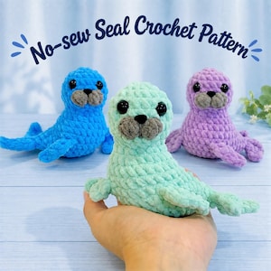 May include: Three plush seal toys made of soft yarn in blue, mint green, and lavender. Each seal features black safety eyes and a gray snout. The text No-sew Seal Crochet Pattern is displayed in dark blue script above the three plush figures.