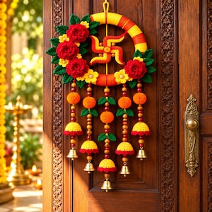 May include: A circular wall hanging featuring a yellow and orange wrapped hoop, adorned with red crocheted flowers, green leaves, and a central yellow swastika symbol. Five hanging strands feature orange pom-poms, yellow bells, and small brass bells.