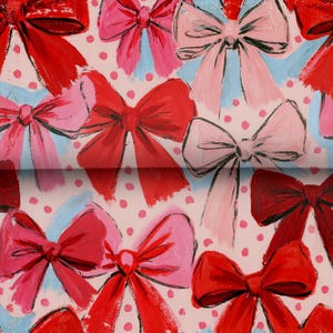 May include: A fabric pattern featuring a repeating design of hand-painted style bows in shades of red and pink, set against a light pink background with small, evenly spaced red polka dots. The bows vary in size and orientation across the surface.