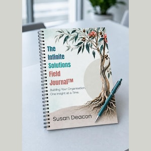 May include: A spiral-bound notebook titled The Infinite Solutions Field Journal, featuring a watercolor illustration of a tree with exposed roots, green leaves, and red flowers. The text includes the author name Susan Deacon and a teal pen.