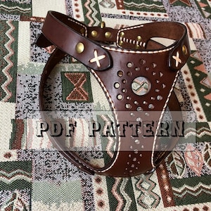 May include: A dark brown leather dog harness featuring a central circular cutout surrounded by smaller perforated holes, brass rivets, and white stitching. The harness includes decorative cross-stitch details and the text PDF PATTERN.