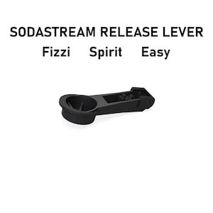 Peut inclure: Un levier de libération noir en plastique pour SodaStream, compatible avec les modèles Fizzi, Spirit et Easy. La pièce présente une extrémité circulaire en forme de coupelle reliée à un bras rectangulaire avec des points de fixation.