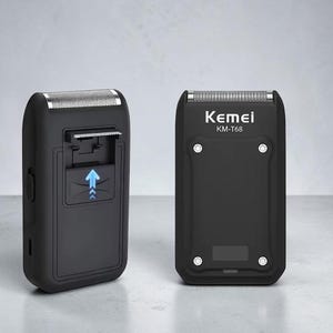 May include: Two black Kemei KM-T68 electric foil shavers. One unit shows a silver foil head and a side switch, while the other displays the front face with the Kemei logo, model number, four silver screws, and a blue arrow icon on the side.