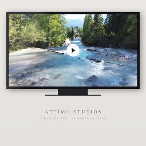 May include: A black flat-screen monitor displaying a video of a turquoise river flowing through a forest with a white play button icon in the center. Below the monitor, the text reads ATTIMO STUDIOS VIDEO PREVIEW - 4K DRONE FOOTAGE.