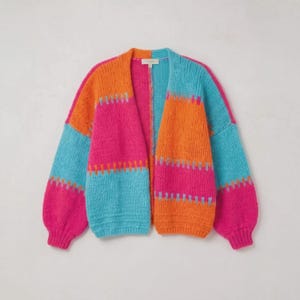May include: A chunky knit cardigan featuring a vibrant colour-blocked design in bright orange, hot pink, and turquoise blue. The open-front sweater has long sleeves with ribbed cuffs and a matching ribbed hem, showcasing a horizontal striped pattern.