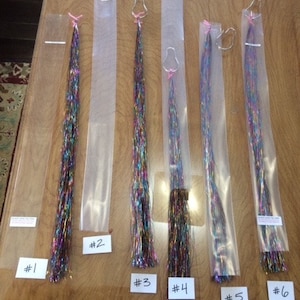 May include: Six packages of iridescent metallic yarn strands, each in a clear plastic bag with a silver clip. The packages are labeled #1 through #6.