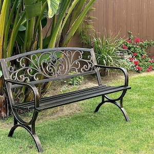 May include: A dark metal garden bench featuring a backrest with intricate scrollwork and a distressed bronze-toned finish. The bench has curved armrests, a slatted seat, and arched legs, providing a sturdy structure for outdoor seating.