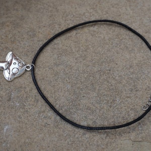 Puede incluir: Un collar con un colgante de hongo plateado, un cord&oacute;n negro y un cierre plateado.