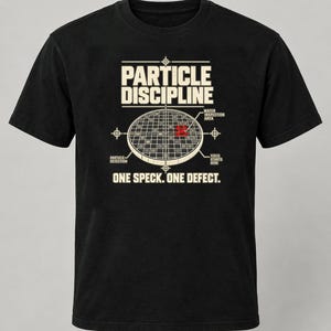 May include: A black short-sleeve t-shirt featuring a graphic print with the text PARTICLE DISCIPLINE and ONE SPECK. ONE DEFECT. The design includes a circular grid diagram labeled WAFER INSPECTION AREA, PARTICLE DETECTION, and YIELD STARTS HERE.