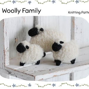 Könnte beinhalten: Drei handgefertigte Schaf-Figuren mit flauschiger weißer Wolle und schwarzen Gesichtern und Füßen. Der Text "Woolly Family" und "Knitting Pattern" ist über den Schafen zu sehen. Die Schafe stehen auf einem weißen Holzregal.