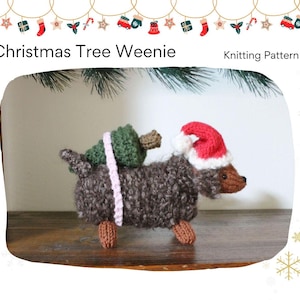 Puede incluir: Un perro salchicha tejido con un gorro de Papá Noel y que lleva un árbol de Navidad verde en la espalda. El perro es marrón y gris, con una correa rosa que sujeta el árbol. El texto "Christmas Tree Weenie Knitting Pattern" está arriba.
