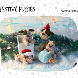Könnte beinhalten: Festliches Bild mit vier gestrickten Welpen-Ornamenten. Die Welpen sind hellbraun und braun, einige tragen Weihnachtsmützen und Schals. Ein Welpe befindet sich in einer weißen Box, ein anderer hält eine blaue Kugel. Der Text "Festive Puppies" und "Knitting Pattern" steht oben.