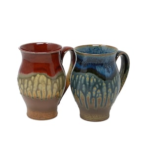 Peut inclure: Deux tasses en céramique avec des motifs de glaçure uniques. Une tasse est rouge foncé avec une glaçure jaune et orange, l'autre est une glaçure bleue et verte.